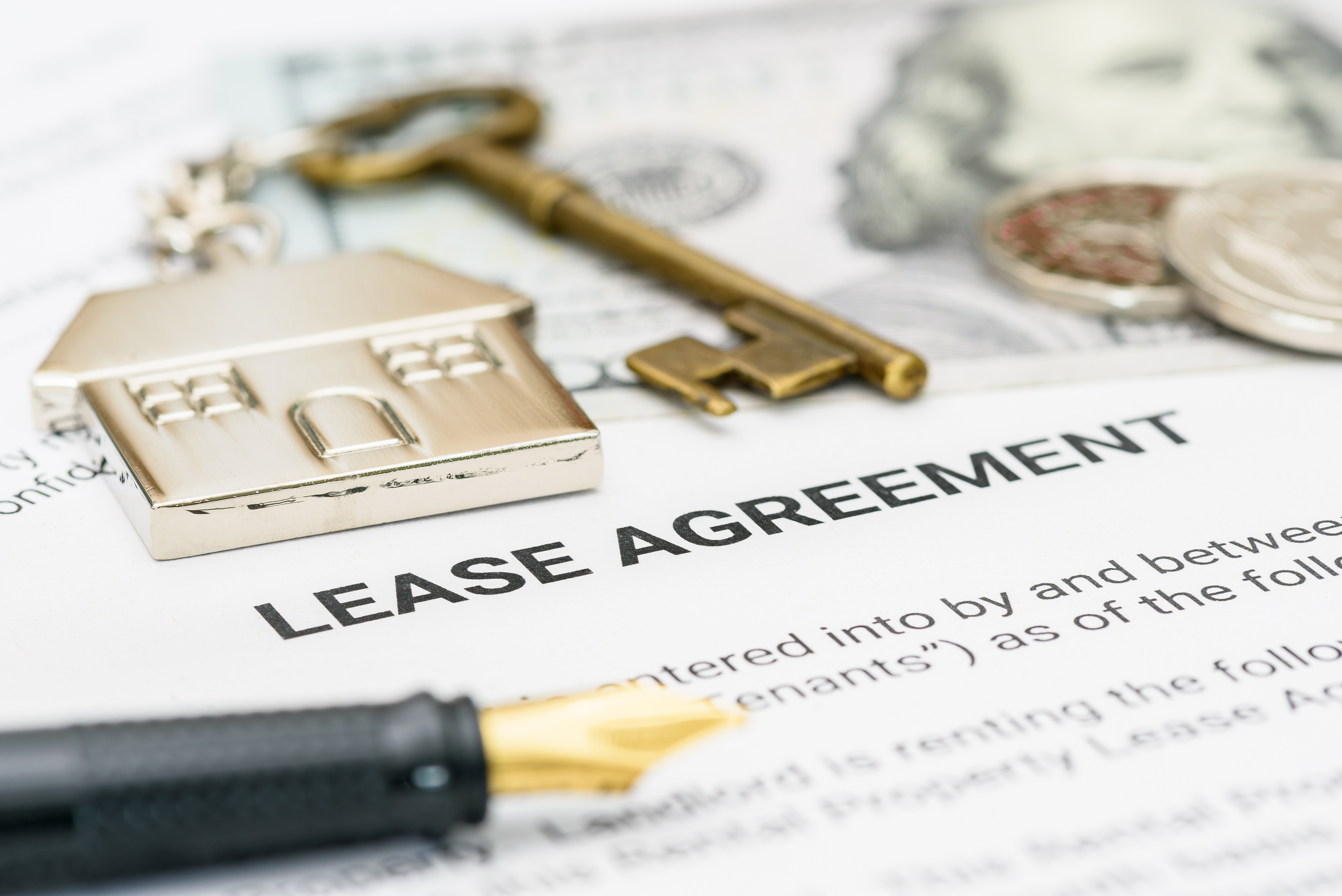 A key and a pen on a lease agreement